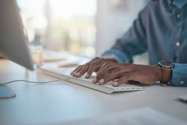 istock Shot of an unrecognisable businessman using a computer at his desk in a modern office 1348066541