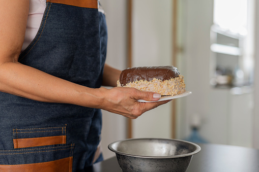 Latina entrepreneur from Bogota Colombia between 40 and 44 years old, prepares the ingredients to make her ice cream package and sell it to her customers during the pandemic