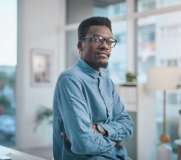 istock Portrait of a confident young businessman working in a modern office 1348068708