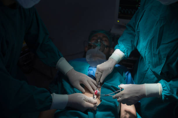 mãos fechadas da equipe da sala de cirurgia realizando cirurgia no hospital. - beijing opera mask china - fotografias e filmes do acervo