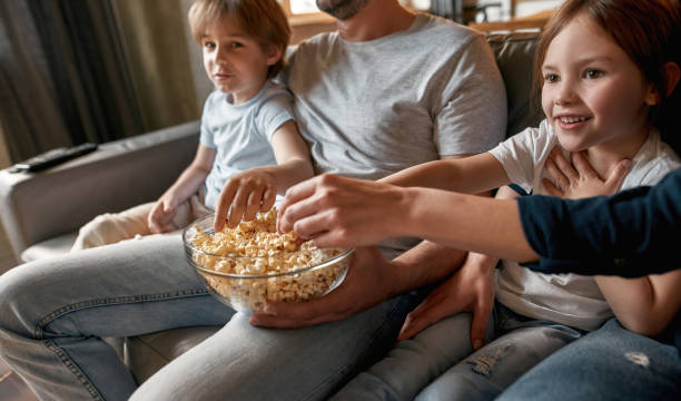 istock Happy kids relax with parents watching TV 1348070108