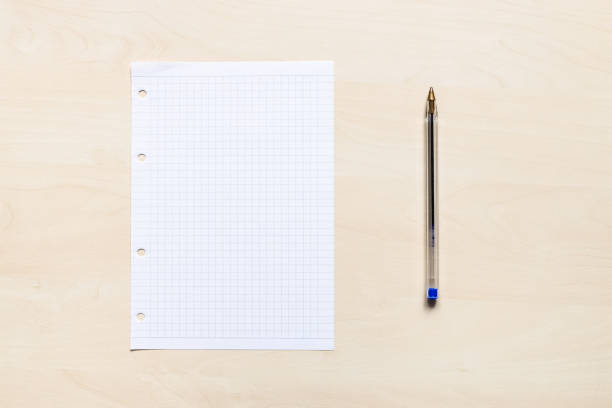 pen and blank squared paper on light board top view of plastic pen and blank sheet of squared paper on light brown wooden board blue ruled stock pictures, royalty-free photos & images