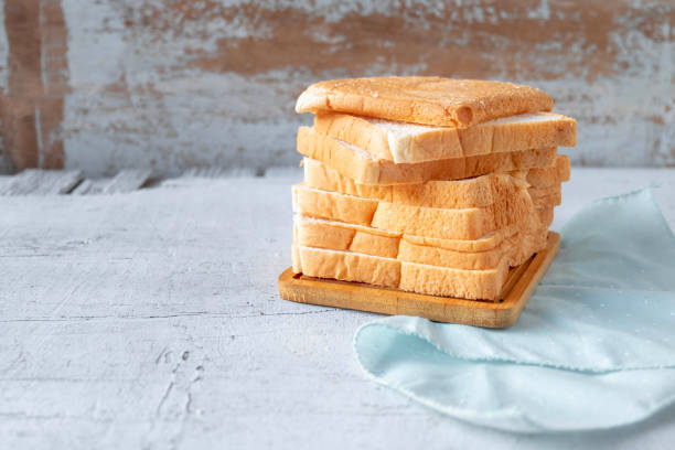 istock Bread slides on white wooden background 1348075395