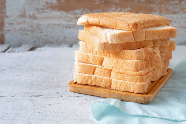istock Bread slides on white wooden background 1348075398