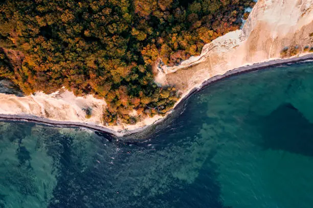 Drone’s eye view looking straight down to the water’s edge where the staircase of 497 reaches the bottom of the cliff. Photographed in the early autumn on the island of Moen in Denmark. Colour, horizontal with some copy space.