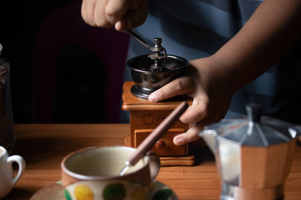 istock Hand spinning the coffee bean grinder grind enough coffee. 1348076510