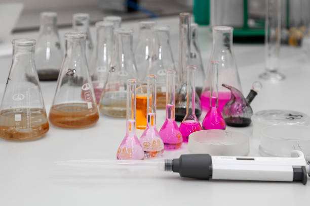 istock Composition of laboratory material with colored liquids in realistic glass pots 1348077903