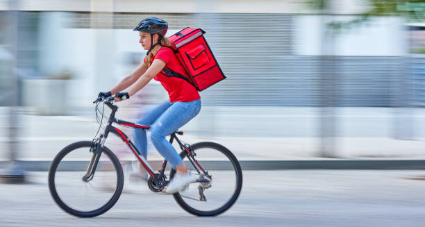 bike messenger courier delivering in city with motion blur - bicycle messenger imagens e fotografias de stock