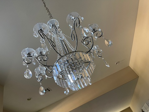 A beautiful chandelier is installed in the center of the atrium with a skylight above.