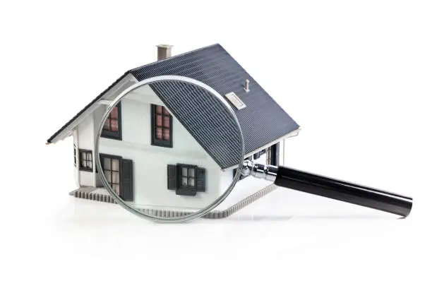 Photo of House model with magnifying glass home inspection or searching for a house