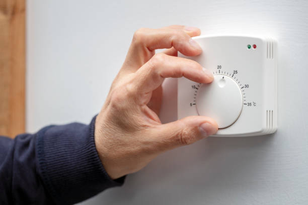 einstellung der thermostatsteuerung der zentralheizung - saving electricity stock-fotos und bilder