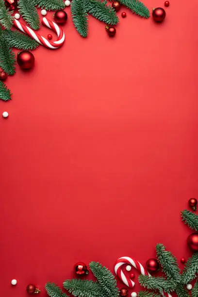 Photo of Red Christmas background with fir branches and decorations