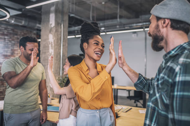 istock Smiling guys and girls gesturing friendly in office 1348082368