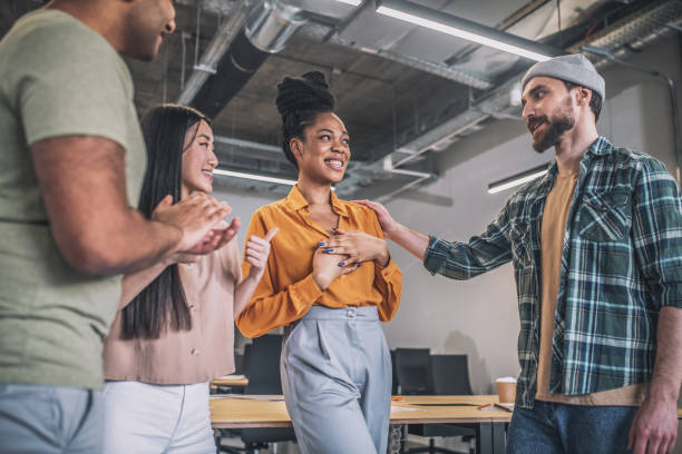istock Smiling guys and girls happily communicating in office 1348082375