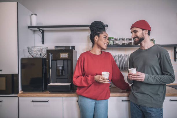 istock Smiling guy and girl in profile with coffee 1348082405