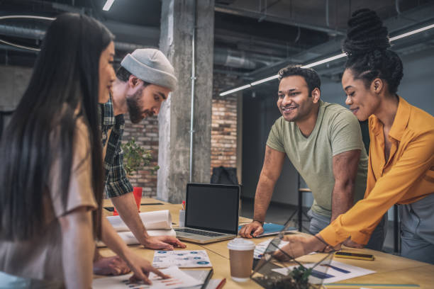 istock Four interracial smiling people in office 1348082458