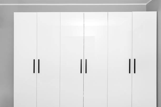 istock Large and high wardrobe in the bedroom with white fronts and black handles. 1348082485