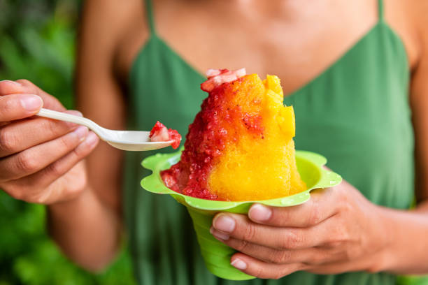 shave ice hawaii cibo locale donna che mangia hawaiano gelato rasato trattare a honolulu waikiki beach, hawaii, usa - waikiki beach foto e immagini stock