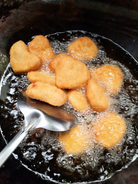 Frying Chicken Nuggets in cooking pan - food preparation. stock photo