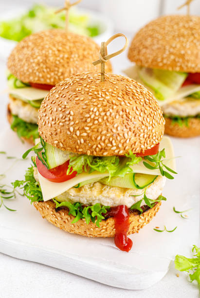 istock Hamburger with grilled chicken burger, fresh cucumber, tomato, cheese and lettuce. 1348089526