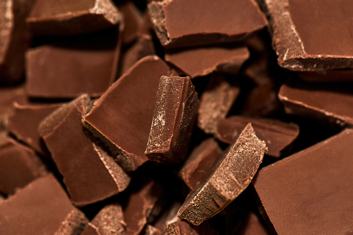 Close up shot of sweet delicious broken milk dark chocolate bar stack. Sweet junk food, dessert concept. Horizontal shot