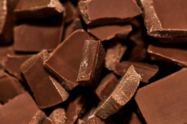 Close up shot of sweet delicious broken milk dark chocolate bar stack stock photo