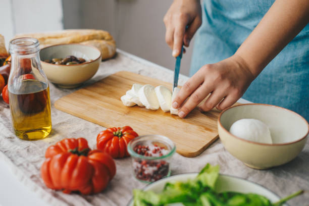 donna che cucina insalata caprese - mature adult foto e immagini stock