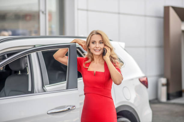 istock Woman talking on smartphone near car 1348093774