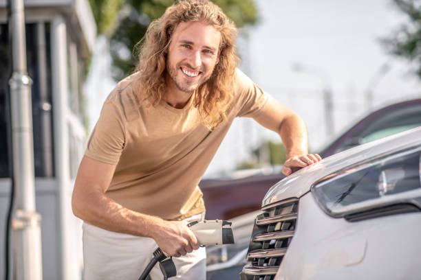 istock Cheerful affable young man cleaning car 1348093788