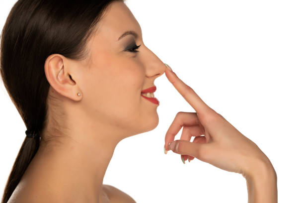 istock profile of a young smiling woman touching her nose 1348094530