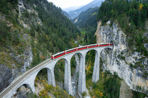 Train crossing Landwasser Viaduct on raethian railway in Filisur – Albula, Graubunden, Switzerland \nThe Landwasser Viaduct is a single track limestone railway viaduct near Filisur in the canton of Graubünden, Switzerland.
