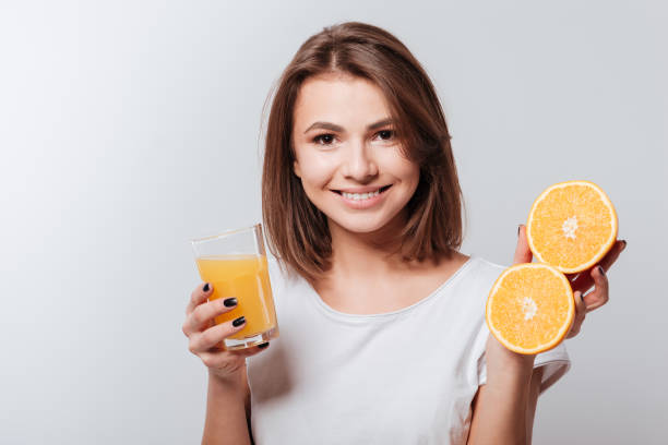 istock Attractive young lady holding orange and juice 1348095792