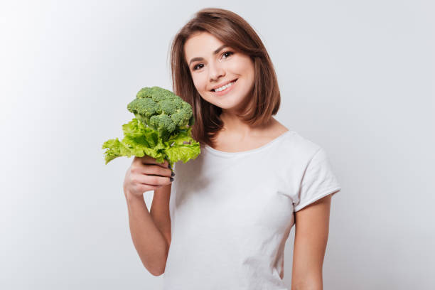 istock Cheerful young lady holding broccoli 1348096107