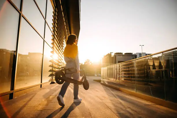 Beautiful young girl is wearing an electric scooter