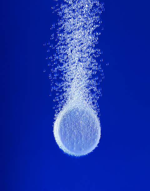 Pill in water XXL Effervescent tablet in water with bubbles aspirin photos stock pictures, royalty-free photos & images