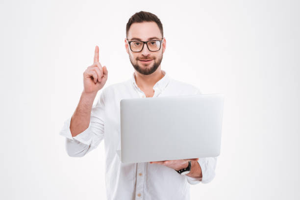 istock Concentrated young bearded man using laptop and pointing 1348101543
