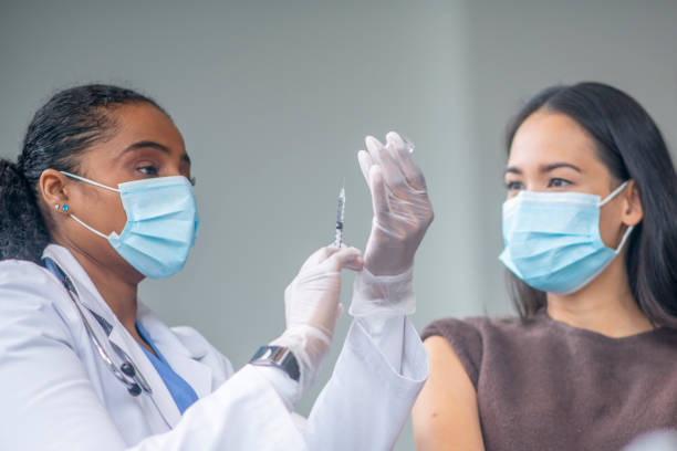 istock Doctor Preparing a Patients Vaccine Syringe 1348102178