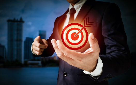A businessman mentions In the center of a circular target, a red dart is placed. Communicate the target's company success via a vertical graphic.