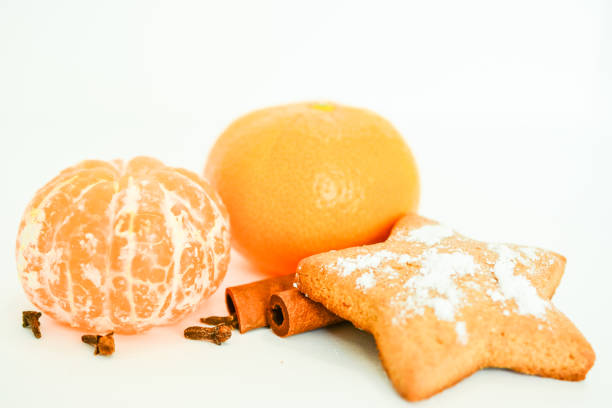 tangerine with cinnamon rolls and star cookie on white background, close-up