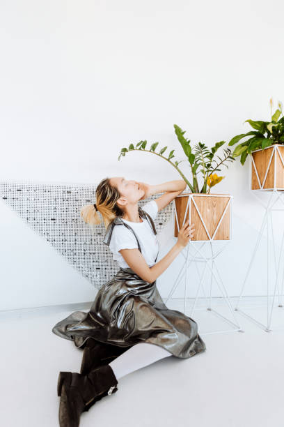 istock Attractive young asian lady posing over white wall with plants 1348103151