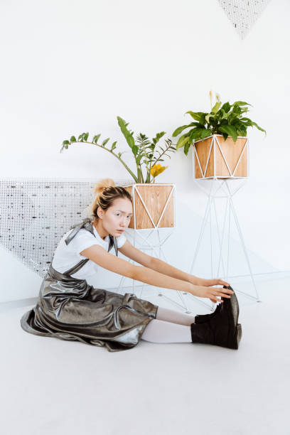 istock Serious young asian lady posing over white wall with plants 1348103268