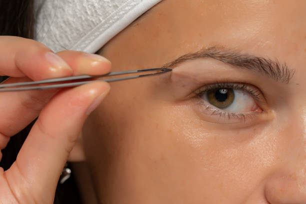 istock woman shapes her eyebrows 1348105464