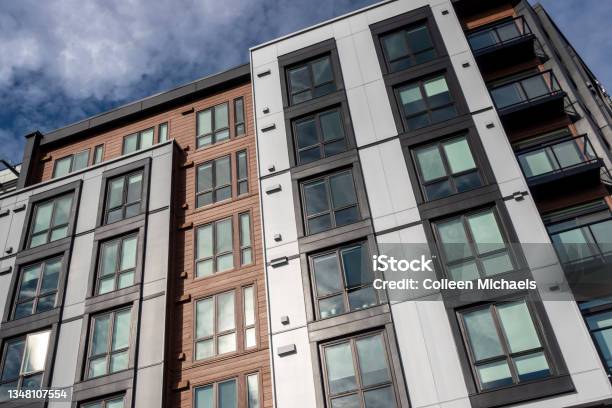 Low Angle View Of A Modern Style Business Building With Lots Of Windows On A Sunny Cloudy Day Stock Photo - Download Image Now