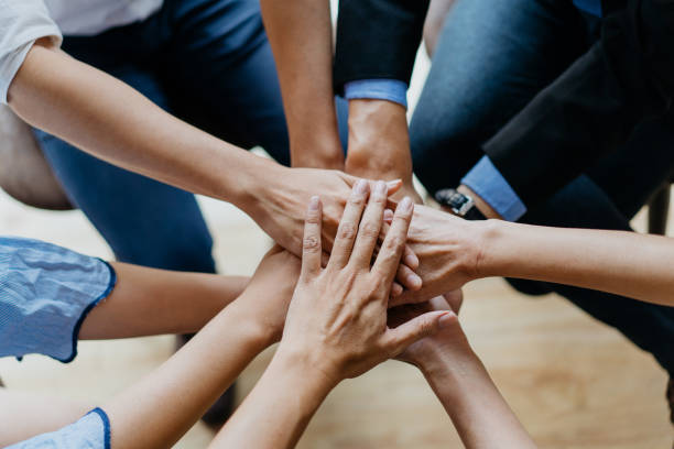 Together we can do it Image of a group of Asian business people stacking hands in office stacked hands photos stock pictures, royalty-free photos & images