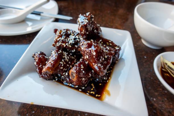 istock saucy baby back pork ribs on a white square plate inside an Asian restaurant 1348108794