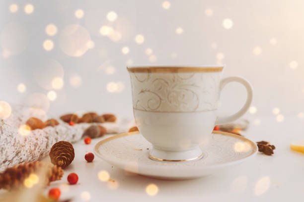 Morning coffe or tea in a white cup with beautiful glowing bokeh at the background