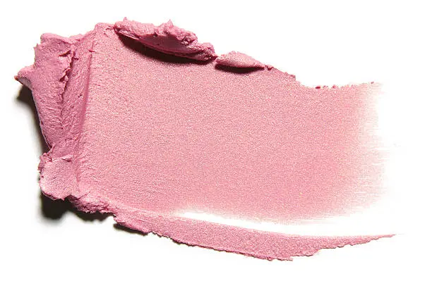Sample of pink compact cream on white background