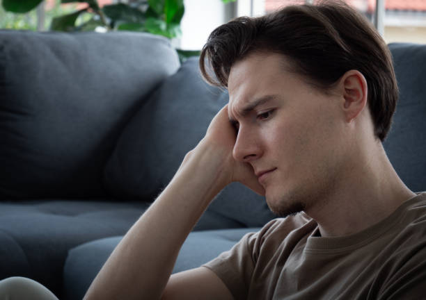 istock Close up handsome young man Anxious, worried, and bored expression. A young man sits and works in a work-from-home manner, but becomes bored and worried, possibly due to depression. 1348111946