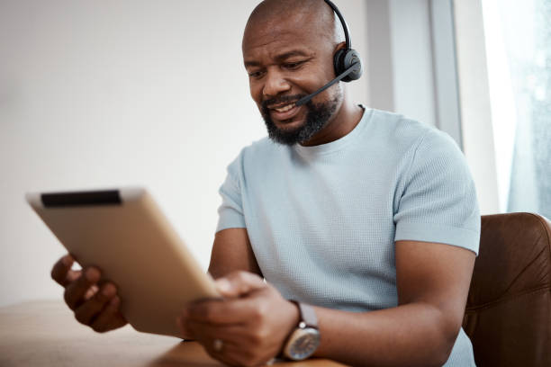 istock Shot of a man using a digital tablet while working in a call center 1348113230