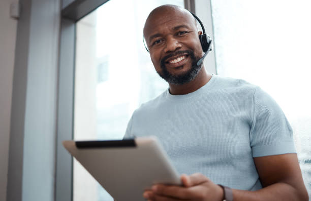 istock Shot of a man using a digital tablet while working in a call center 1348113234